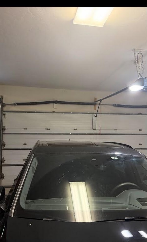 Interior residential garage door with spring and lifting hardware visible above the door