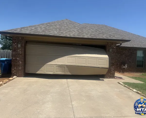 Garage door with a visibly bowed and damaged lower section