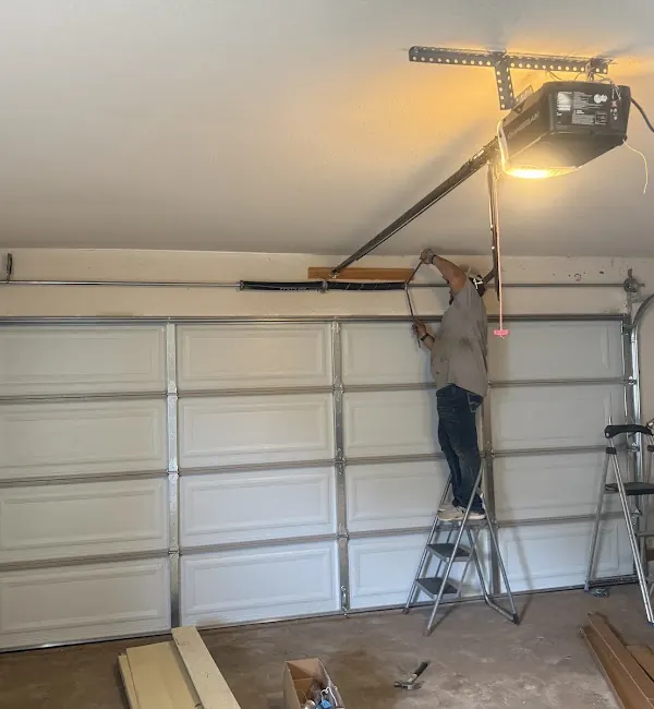 MTA Garage Doors technician working near residential top-of-door hardware