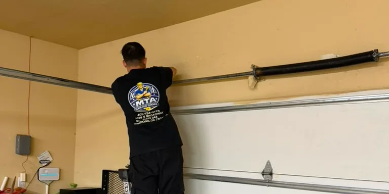 MTA Garage Doors technician inspecting residential garage door tracks and hardware