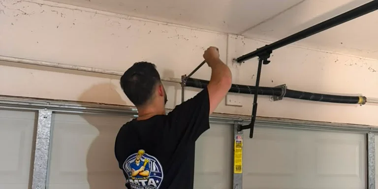 MTA Garage Doors technician servicing a residential garage door spring system