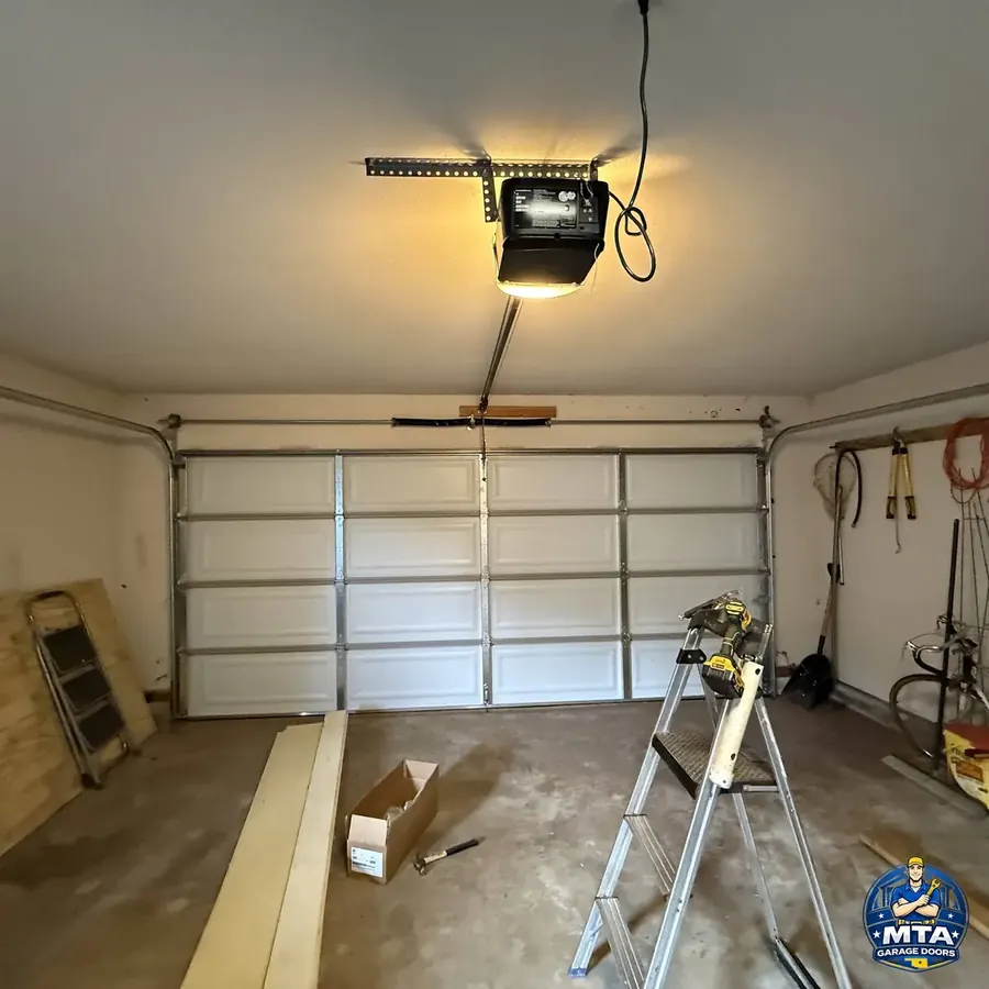 Interior residential garage with ceiling-mounted opener and sectional door visible